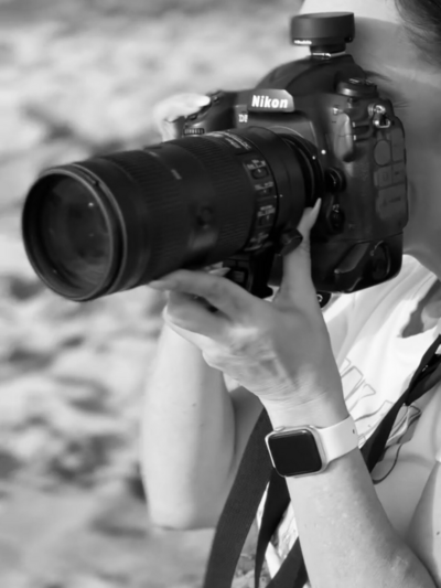 professional female photographer with a nikon d5 up to her eye