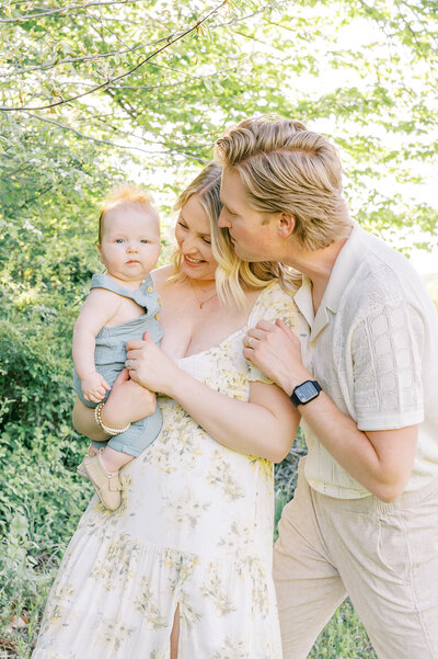 Women and man adoring their baby during spring photo session