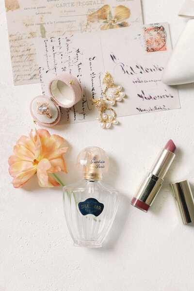flat lay of bridal details perfume makeup