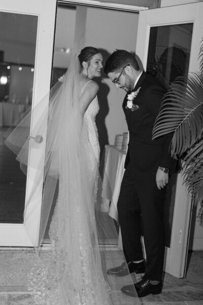 Groom holding the door open for his bride after they exchanged their vows at the Stallion Restaurant in Wellington, Florida. Photo by Maggie Alvarez Photography