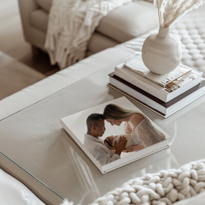 Heirloom quality album of newborn session sitting on coffee table in living room. Jenni Nikki Photography sells these albums to her Woodstock clients.