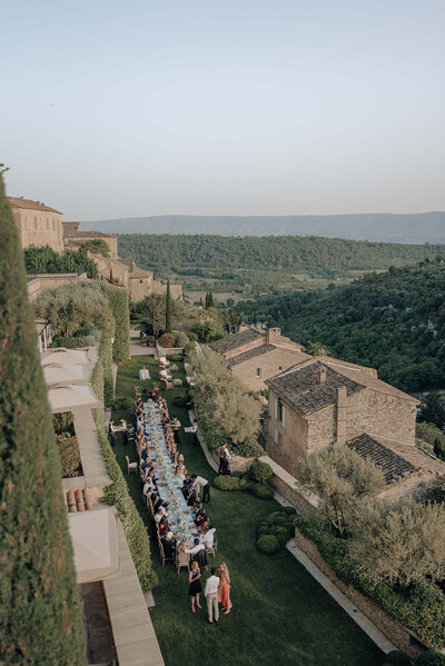 Long rectangular wedding dinner table in a terraced garden at Bastide de Gordes overlooking the Luberon Valley