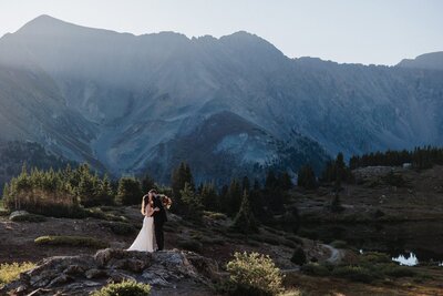 bride and groom stand on rock and say wedding vows after planning their colorado elopement