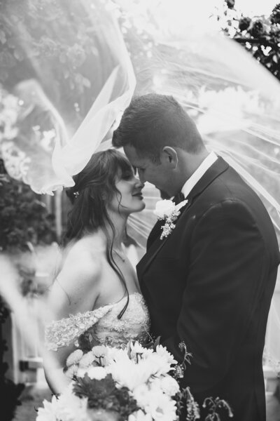 newlyweds kissing under veil