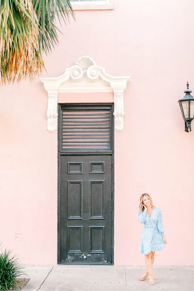 Kara Blakeman Photography stands in front of the Pink Mills House in Charleston, SC for branding portraits