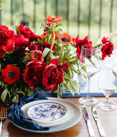 Bright and bold wedding table setting with red poppy florals and vintage blue china at Montaluce Winery