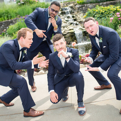 groom and groomsmen pose playfully