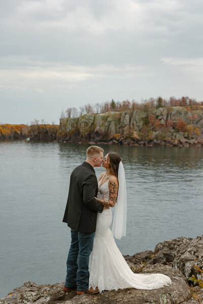 Married couple taking elopement photos on Black Beach in Silver Bay, Minnesota