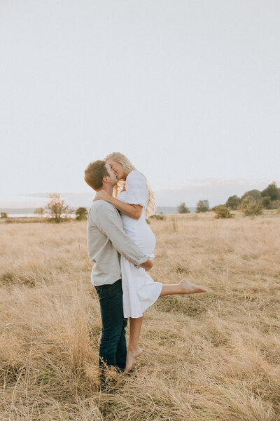 couple sitting in a field while looking at each other