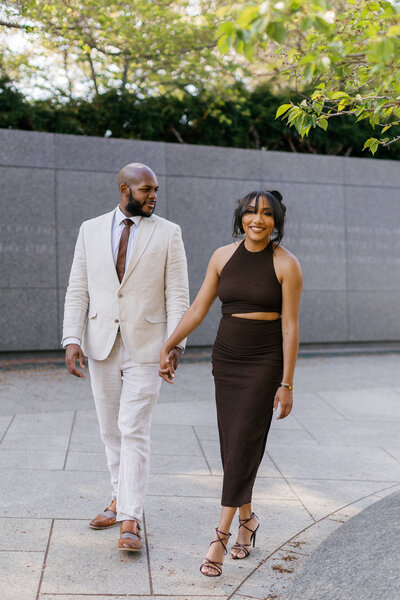 A couple walks hand in hand in DC during their elegant engagement session