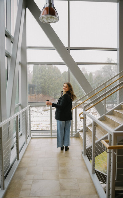 Social media manager holding coffee mug and smirking at camera