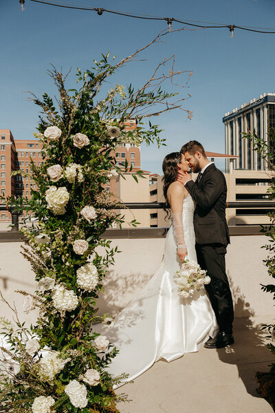 couple on rooftop kissing on wedding day