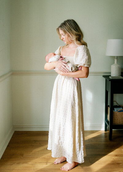 Mom in a long dress holding her baby