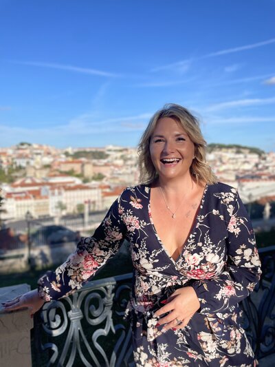 Maggie Dickens, LPCS, smiling outdoors in a floral dress, representing a compassionate therapist who helps women overcome burnout, perfectionism, and emotional overwhelm through feminist, values-based therapy.