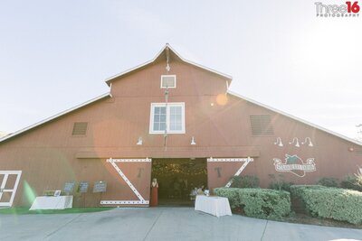 Bridesmaid stands at the barn entrance during the wedding reception at the Strawberry Farms Golf Course