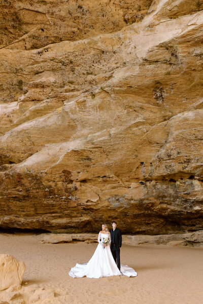 Bride holding up a bouquet of flowers during a beach elopement in Michigan.