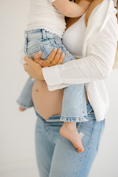 toddler girl on moms baby bump in a studio in lodi california