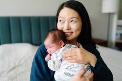 Mother and newborn baby boy snuggled together