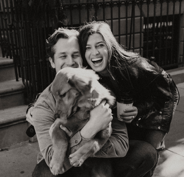 A couple posing with their dog 