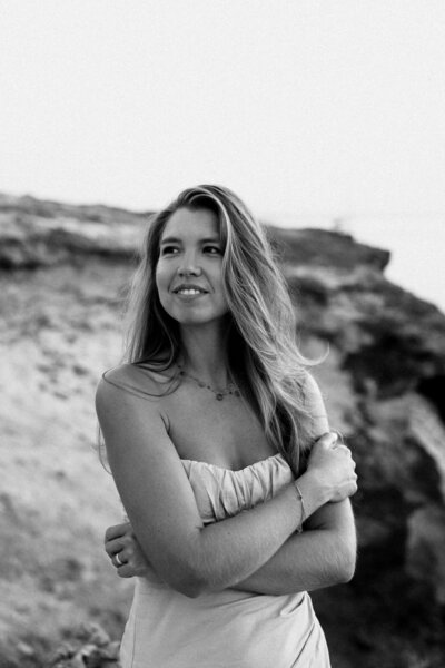 Photographer is posing in front of a big rock for personal branding photoshoot during sunset
