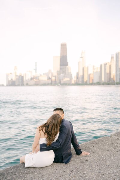 Couple sitting on a pier overlooking the Chicago skyline at sunset