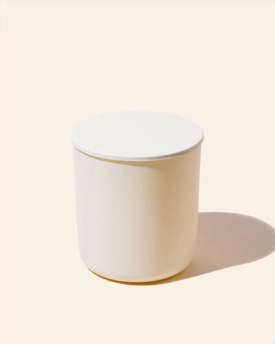 Noura Blanc Aura Candle in Cream Small with lid on flat lay