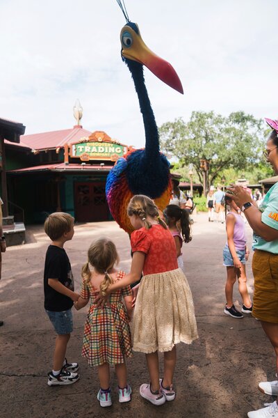 Kids in rainbow and Moana outfits seeing Kevin in animal Kingdom