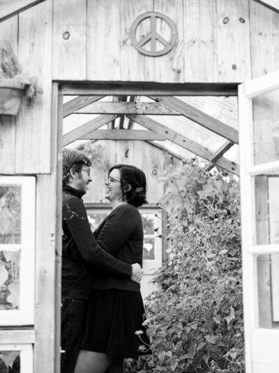 A peeking image into a greenhouse while a couple gazed smiling at each other