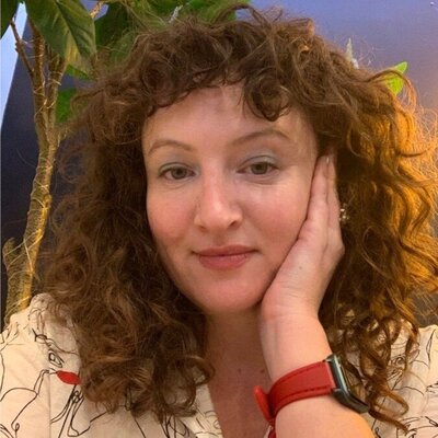 Alexis has curly brown hair and smiles