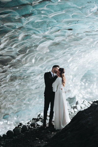 bride and groom embracing in Iceland glacier cave