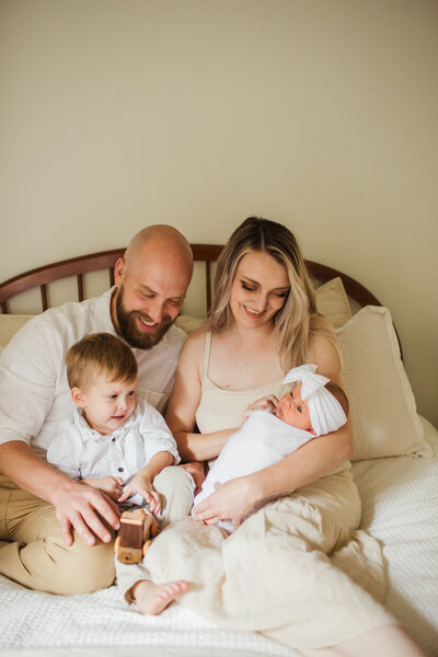 young family smiling and celebrating recent baby during newborn session