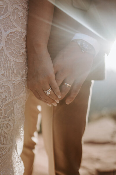 Bride and groom holding hands during an adventurous elopement in Zion National Park—intimate and scenic wedding moment surrounded by breathtaking red rock landscapes, planned by Watters & Co. Events.