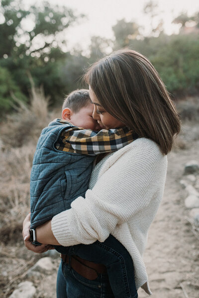 Asian mother and toddler son hug on Pasadena trail