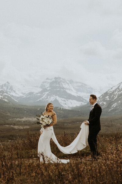 bride and groom walking together in front of mountains in montana during their elopement