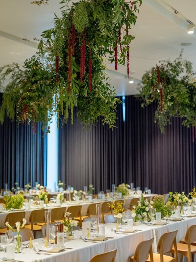 Corporate event decor featuring modern tablescapes and lush hanging greenery, designed for impactful Austin corporate event styling.