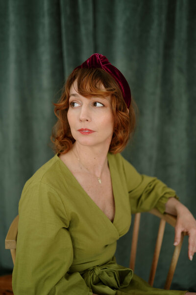 Woman seated in a chair wearing a green dress