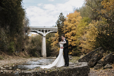Bride and Groom posing at the river  in the autumn