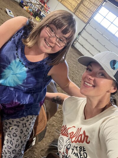 Spirit's Respite Ranch coach taking a photo with a child riding a horse.