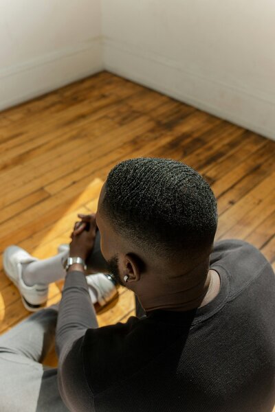 a black teenager sitting on the floor while talking to a therapist