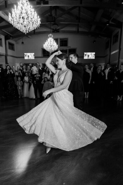 groom twirling bride during their first dance at black river barn