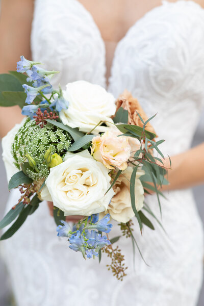 An Austin-based wedding photographer captures a bride holding a bouquet of blue and white flowers.