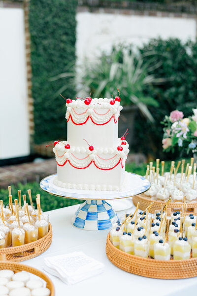 Luxury vintage style cake with modern blue and white checkered cake stand surrounded by various desserts 