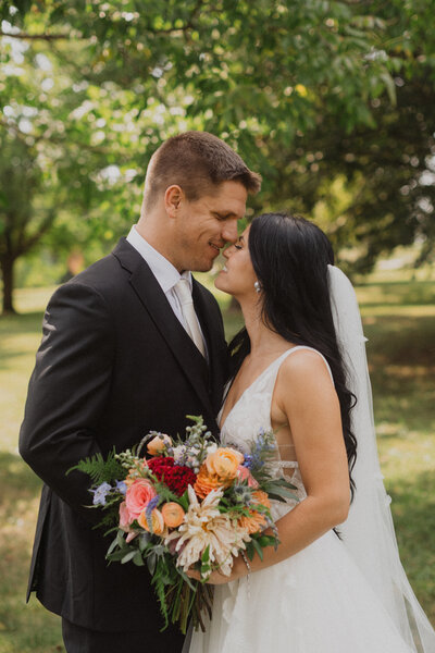 bride and groom embracing with church in the background