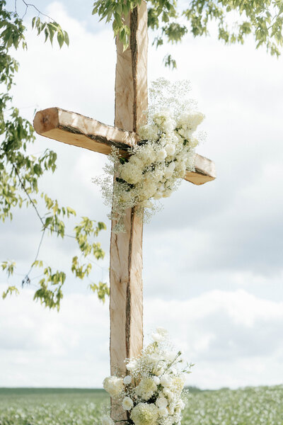 wooden cross covered in flowers