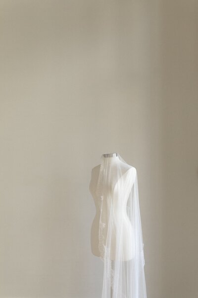 Mannequin draped with a long veil in a studio.