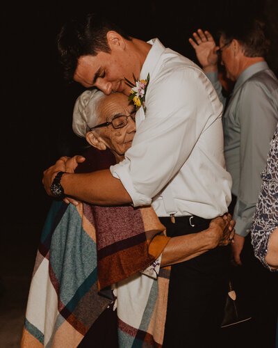 A groom hugging his grandmother.