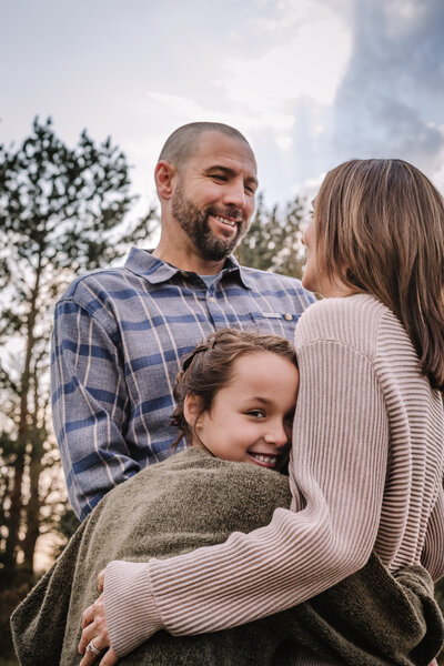A family of three cuddle together. 