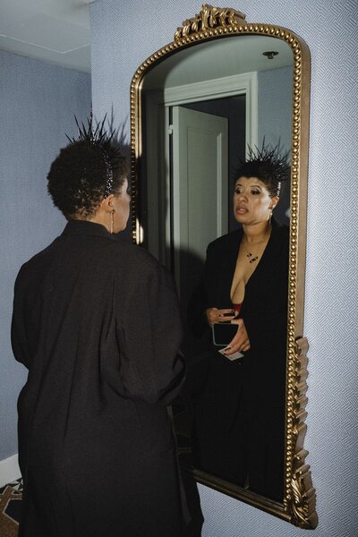Bride putting on her crown and black suit for her downtown Providence wedding. Photography by Rhode Tripper Photography