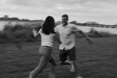 A couple running around together in a field 