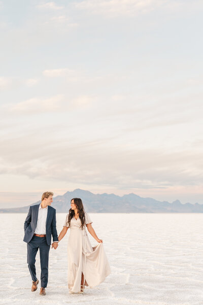 Sweet, romantic photo of a couple. He is carrying her in his arms while walking across Sleepy Ridge  Golf Course towards the Venue. Photo taken by Utah Wedding Photographers Andria Joleen Photography